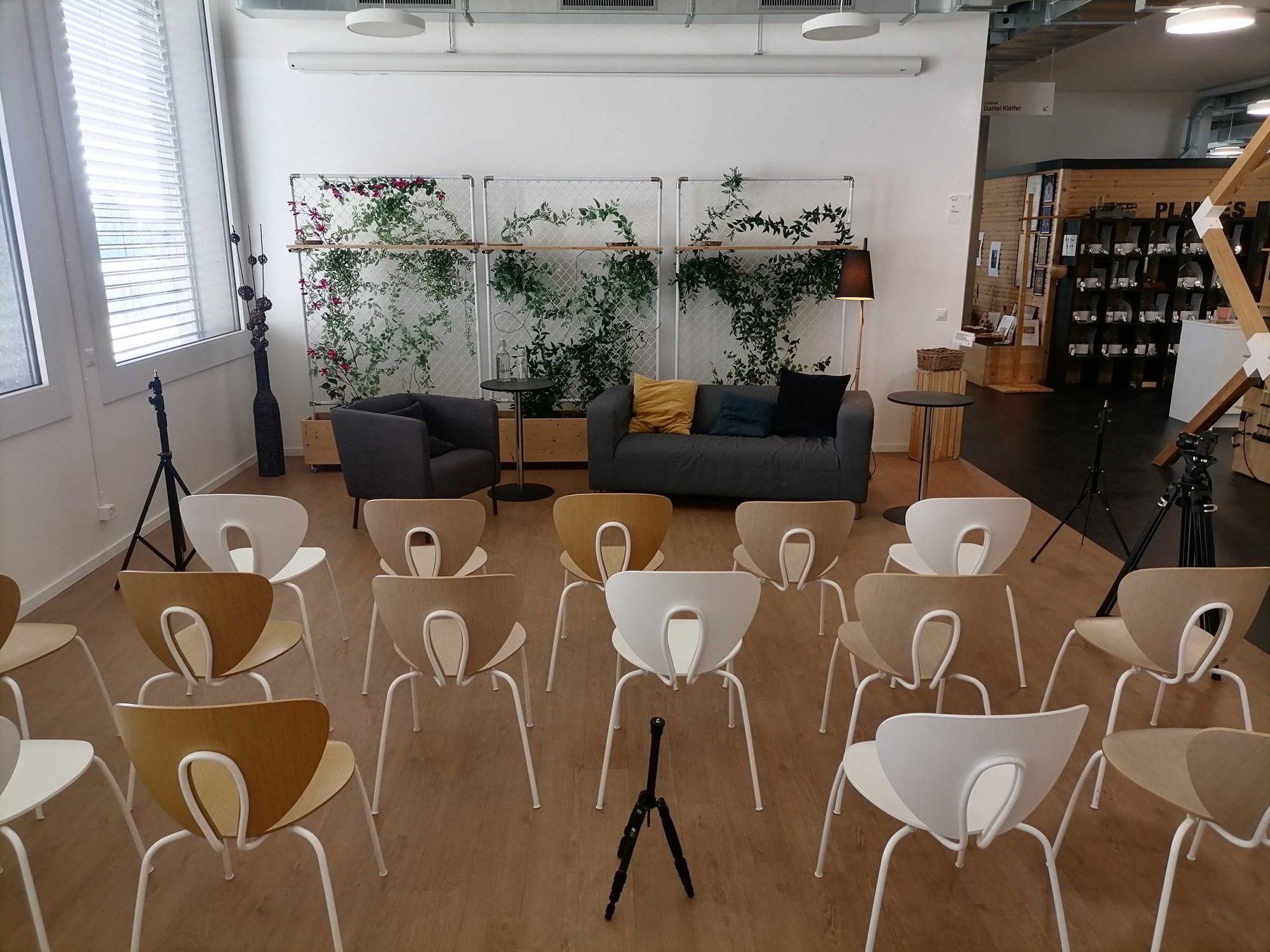 L'open space en disposition conférence, avec le mur végétal et le coin canapé